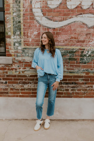 Model wearing oversized mineral wash sweatshirt in Peri blue.