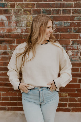 beige sweater with black detail stitching