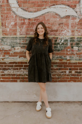 Model wearing black denim mineral wash dress.