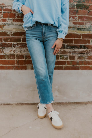 Model wearing straight leg jeans and sneakers.